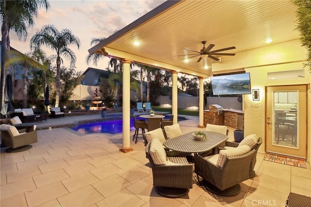 view of patio / terrace featuring ceiling fan, outdoor dining area, an outdoor kitchen, fence, and a fenced in pool