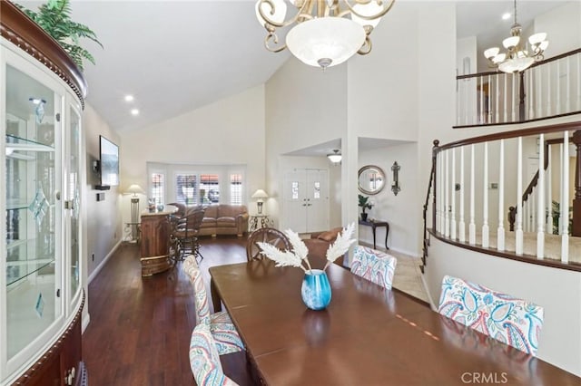 dining area with dark wood finished floors, a notable chandelier, baseboards, and stairs