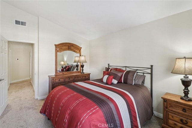 bedroom with light carpet, lofted ceiling, visible vents, and baseboards