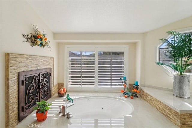 interior space with a garden tub and a fireplace