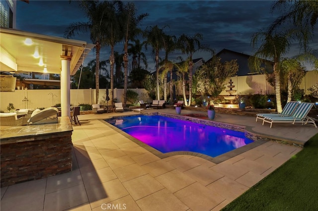 pool at twilight with a patio area, a fenced backyard, and a fenced in pool