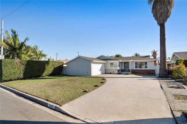 ranch-style house featuring concrete driveway, a front lawn, an attached garage, and fence