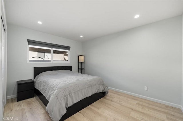 bedroom featuring light wood finished floors, baseboards, and recessed lighting