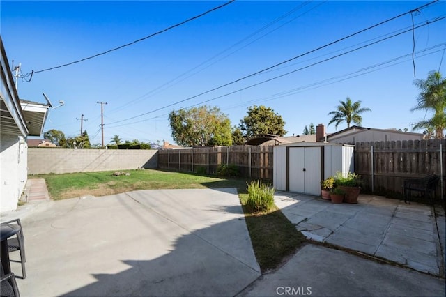 view of patio / terrace with a storage shed, an outbuilding, and a fenced backyard