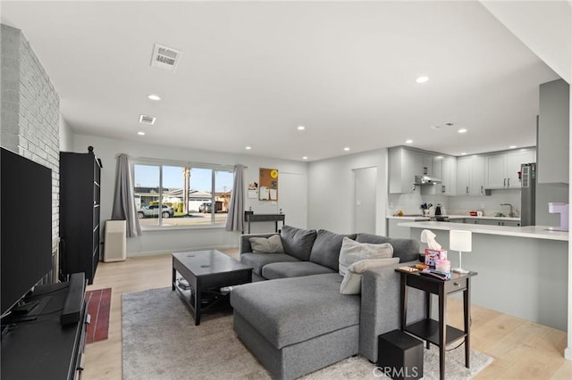 living area featuring light wood-style floors, visible vents, and recessed lighting