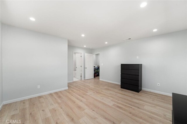 empty room featuring recessed lighting, baseboards, and light wood finished floors