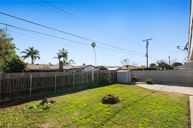 view of yard with a shed, a patio area, a fenced backyard, and an outdoor structure