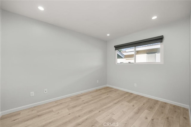 spare room featuring light wood-type flooring, baseboards, and recessed lighting