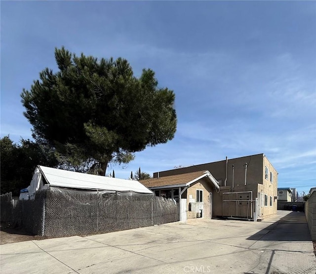 view of front facade with fence and stucco siding