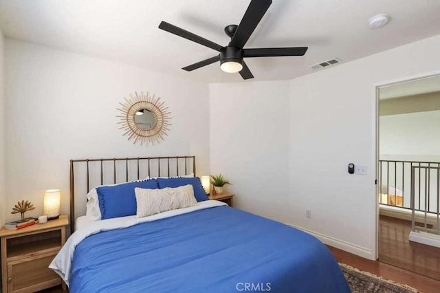 bedroom featuring a ceiling fan, baseboards, visible vents, and dark wood-type flooring