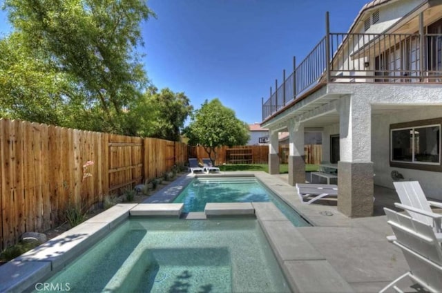 view of pool featuring a patio area, a fenced backyard, and a pool with connected hot tub