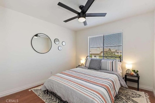 bedroom with a ceiling fan, baseboards, and wood finished floors