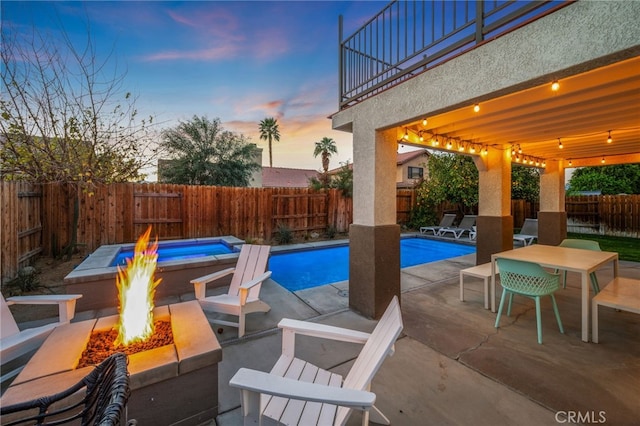 view of swimming pool featuring a fenced backyard, a fire pit, a fenced in pool, outdoor dining space, and a patio area