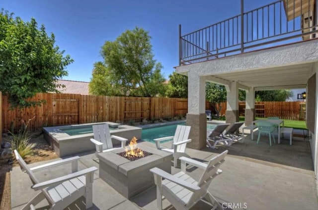 view of patio / terrace featuring a fenced in pool, a fenced backyard, a fire pit, and an in ground hot tub