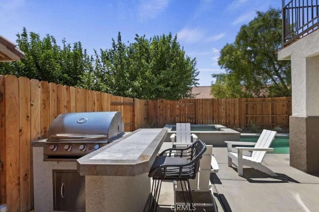 view of patio featuring a bar, a fenced backyard, and area for grilling