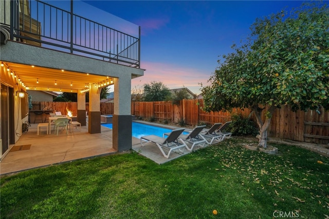 view of pool with a fenced in pool, a patio area, a lawn, and a fenced backyard