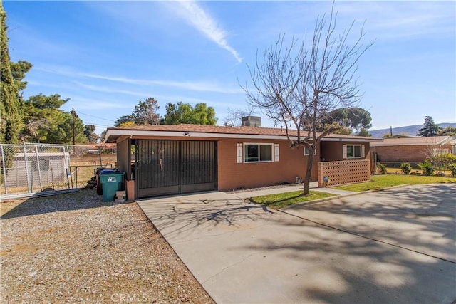 view of front of house with driveway, an attached garage, fence, and a gate