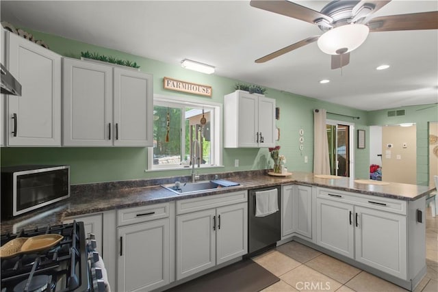 kitchen with stainless steel appliances, a peninsula, a sink, visible vents, and dark countertops