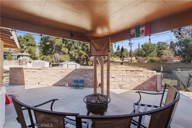 view of patio featuring a fire pit, outdoor dining area, and fence