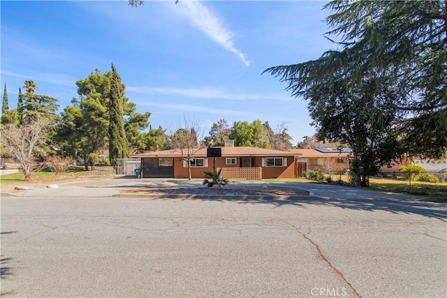 single story home with driveway, a chimney, and an attached garage