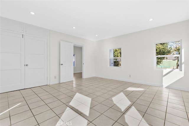 empty room featuring a wealth of natural light, recessed lighting, and light tile patterned floors