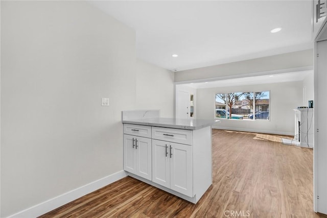 kitchen featuring recessed lighting, light countertops, light wood-style floors, white cabinetry, and baseboards