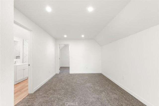 interior space with lofted ceiling, baseboards, light colored carpet, and recessed lighting