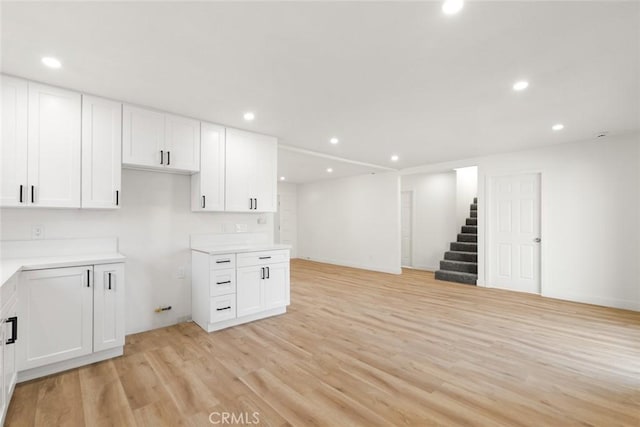 kitchen featuring light wood-style flooring, white cabinetry, light countertops, and recessed lighting