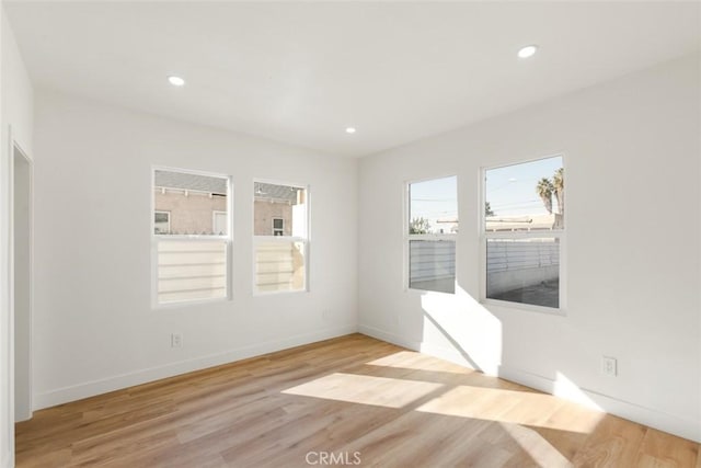 spare room with baseboards, light wood-type flooring, and recessed lighting