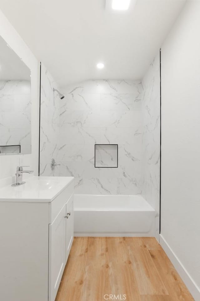 bathroom with bathtub / shower combination, wood finished floors, and vanity