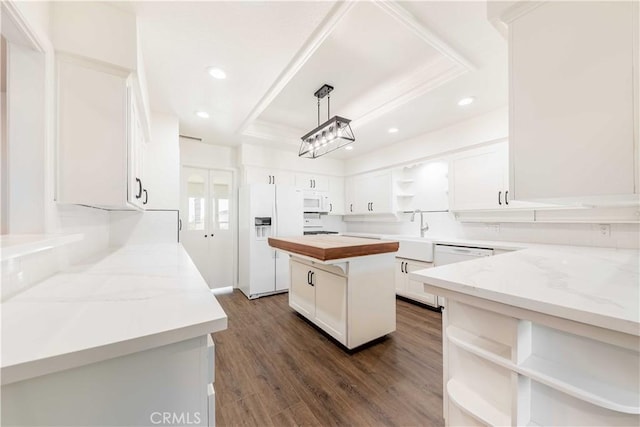 kitchen featuring white appliances, white cabinetry, a center island, open shelves, and decorative light fixtures