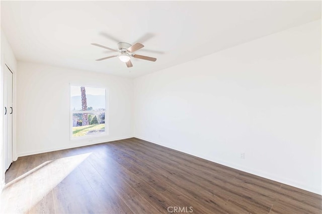 spare room with dark wood finished floors and ceiling fan