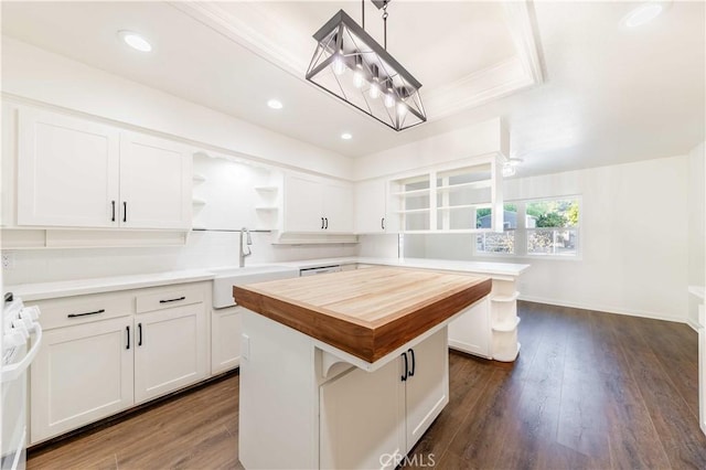 kitchen with white cabinets, open shelves, a sink, and a center island