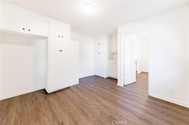 spare room with dark wood-type flooring and baseboards