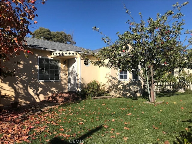 view of property exterior featuring a lawn and stucco siding