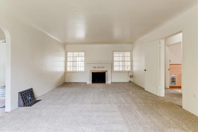 551 Hathway Ave, San Luis Obispo, CA 93405 - unfurnished living room with arched walkways, a fireplace with flush hearth, and carpet floors