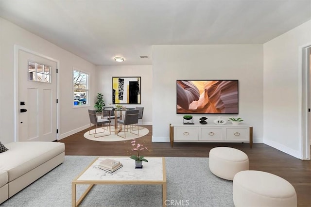 living area featuring dark wood-type flooring, visible vents, and baseboards