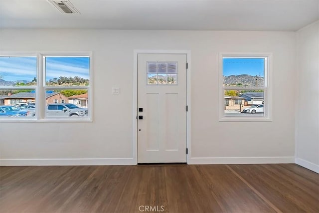 entrance foyer with dark wood-style floors, baseboards, and visible vents