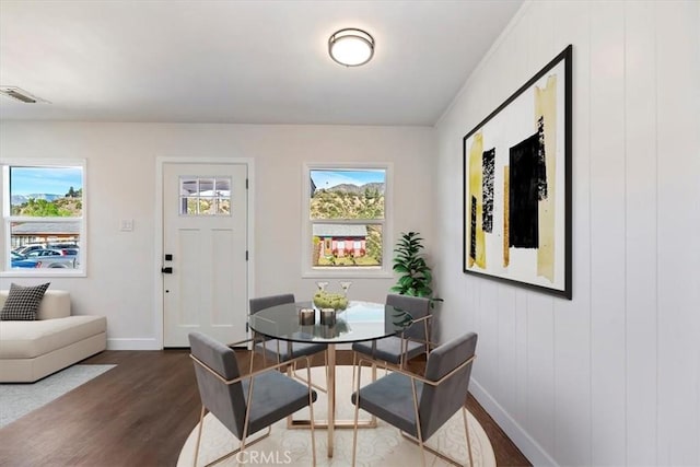 dining space with plenty of natural light, dark wood finished floors, visible vents, and baseboards