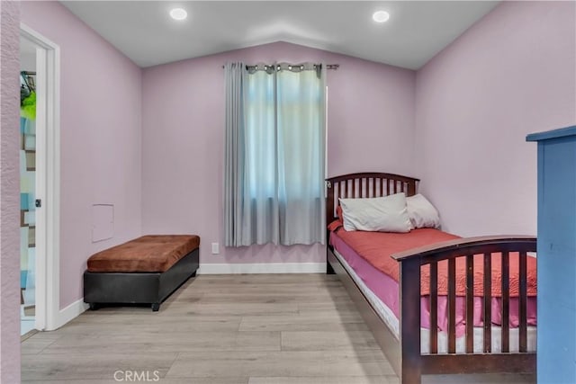 bedroom with lofted ceiling, recessed lighting, light wood-type flooring, and baseboards