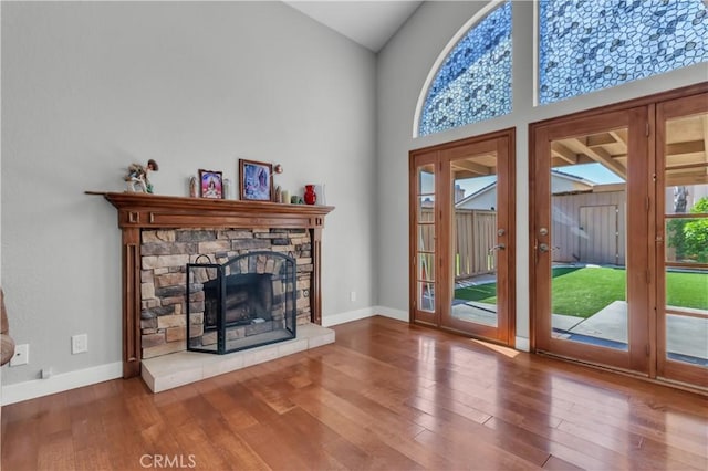 doorway with a fireplace, wood finished floors, and baseboards