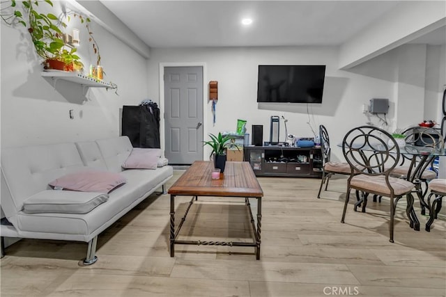 living room with light wood-type flooring and recessed lighting