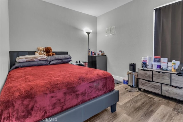 bedroom featuring wood finished floors and baseboards