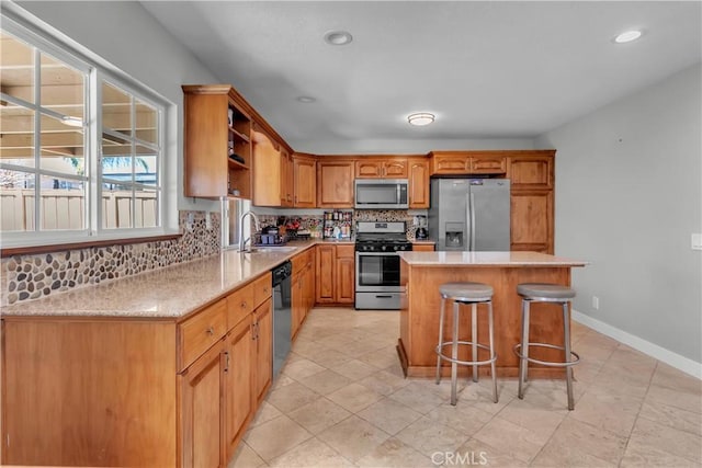 kitchen featuring stainless steel appliances, a center island, brown cabinets, and light countertops