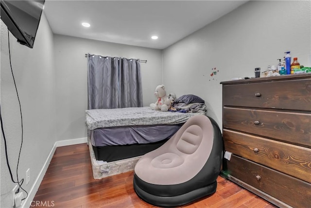 bedroom with baseboards, wood finished floors, and recessed lighting