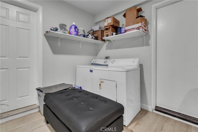 washroom with laundry area, light wood finished floors, and washing machine and clothes dryer