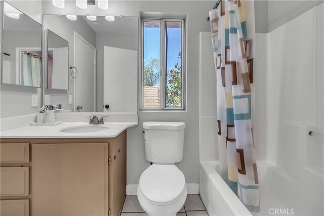 full bath featuring shower / tub combo, baseboards, toilet, tile patterned flooring, and vanity