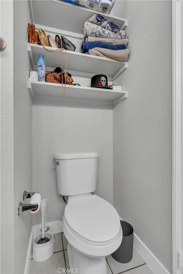 bathroom featuring toilet, tile patterned flooring, and baseboards