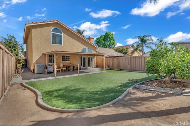 rear view of house featuring a fenced backyard, a yard, a patio area, central AC, and stucco siding