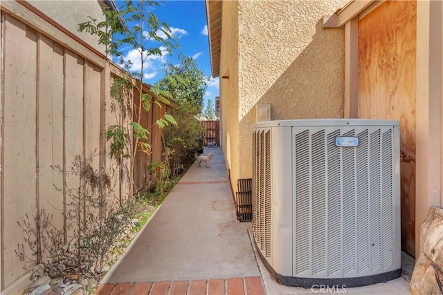 details with cooling unit, a fenced backyard, and stucco siding